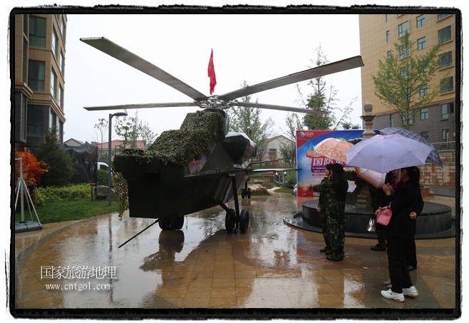 小區(qū)突然出現(xiàn)“飛機(jī)坦克”，其中殲15艦載戰(zhàn)斗機(jī)一架、99式主戰(zhàn)坦克一輛、武直-10武裝直升機(jī)一架，吸引了眾多市民雨中圍觀、合影。